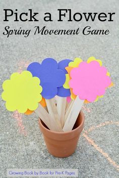 flowers made out of popsicle sticks sitting in a flower pot with the words pick a flower spring movement game