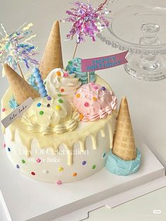 a birthday cake decorated with ice cream and sprinkles on a white table