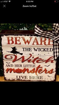 a wooden sign that says beware the witch and her little monsters live here