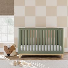 a baby crib in the corner of a room with checkered wall paper on the walls