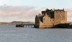 an old castle sitting on top of a body of water