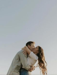 a man and woman kissing on the beach