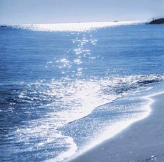 the sun shines on the beach as it reflects off the water's surface