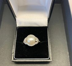 "Vintage stunning chunky pearl ring set with faux diamonds. Lustrous pearl set amongst faux diamonds in solid silver, to create an elegant pearl ring. Please look carefully the photographs as we have taken care to capture any quirks or \"imperfections\" - all our items are commensurate with the age. Vintage and antique jewellery is unlikely to be absolutely perfect, but that's why it's so charming!  Our beautiful silver, gold and platinum rings can be resized for an additional cost - please see Formal Oval Pearl Ring, Turquoise Diamond Rings, Platinum Rings, Diamond Half Eternity Band, Chunky Pearls, Pearl Chain Necklace, Baguette Diamond Rings, Best Engagement Rings, Silver Spinner Rings