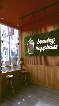 the interior of a coffee shop with wooden walls and plants on the windowsills