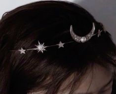 a woman wearing a head piece with stars and moon decorations on it's side