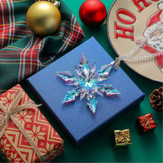 a christmas ornament sitting on top of a blue gift box next to presents