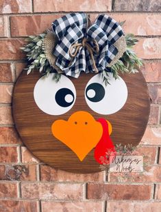 a wooden sign with a turkey on it's face and a bow around its head