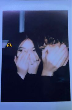 two people covering their faces with their hands