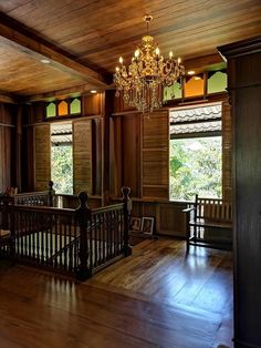 an empty room with wood paneling and chandelier