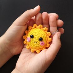 a small crocheted sunflower is being held in someone's hand,