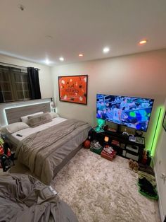 a bed room with a neatly made bed and a flat screen tv on the wall