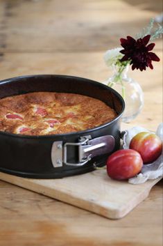 a cake in a pan on a cutting board next to some fruit