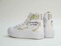 a pair of white sneakers with embroidered flowers on them