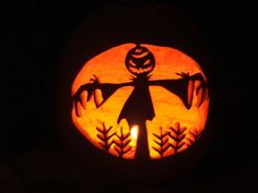 a carved pumpkin with an image of a scarecrow on it's face in the dark