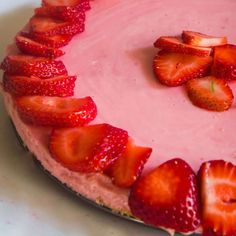 a strawberry cheesecake with sliced strawberries on the top, ready to be eaten