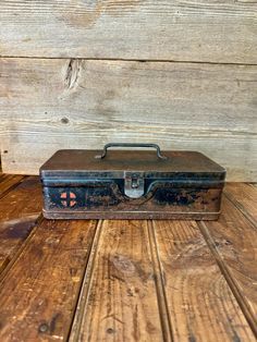 an old suitcase sitting on top of a wooden floor next to a wood paneled wall