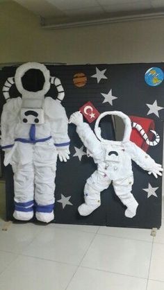 two fake astronaut suits on display in an office