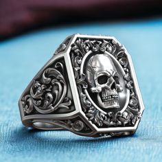 Step into a world of opulence and intrigue with our Royal Vintage Skull Rococo Pattern Signet, crafted from high-quality 925 sterling silver. This exquisite ring features a detailed skull design set against a backdrop of intricate Rococo patterns, embodying a blend of regal elegance and gothic allure. The antique finish adds a touch of vintage charm, making it perfect for those who appreciate unique and sophisticated jewelry. The adjustable band ensures a comfortable fit for any finger size, add Luxury Elegant White Gold Skull Ring, Rococo Pattern, Bold Statement Jewelry, Regal Elegance, Sophisticated Jewelry, Viking Ring, Masonic Ring, Retro Ring, Vintage Skull