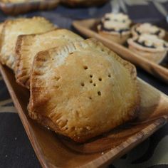 several pastries on wooden trays sitting on a table