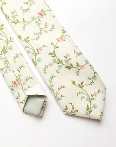 DESCRIPTION: This lovely men's skinny tie has been handmade using an ivory cotton with a pink and green floral print.  FABRIC: Cotton. LINING FABRIC: Cotton. -------------------------------------------------------------------------------------------- DETAILS: * Made the traditional way with fabric cut on the bias * Each tie has canvas lining throughout * Fabric lining just at the tip on each end of the tie * Width at the widest part measures approx 2.5 inches * The length of each tie is approx 5 Spring Black Tie Event Ties, Spring Suit And Tie Accessories For Black Tie Events, Elegant Cotton Ties For Spring, Dapper Formal Ties For Spring, Dapper Spring Formal Ties, Formal Spring Dapper Ties, Spring Cotton Ties For Black Tie Events, Classic Suit And Tie Accessories For Spring Wedding, Elegant Cotton Suit And Tie Accessories For Summer