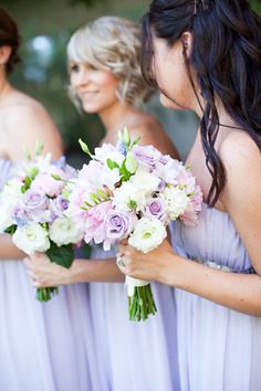 the bridesmaids are holding their bouquets together