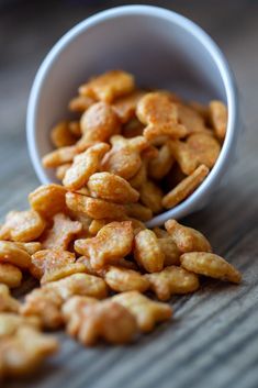 a white bowl filled with nuts on top of a wooden table