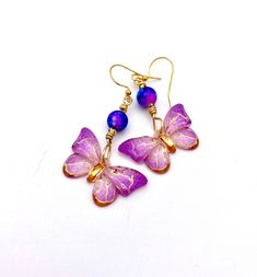 "Beautiful and fun to wear! These earrings feature beautiful butterfly charms in shades of pink-purple and gold.  Each charm is topped with a matching bead.  The butterflies are wired separately and sway as you move.  Gold-plated ear wires. 2\" long X 1.25\" side to side.   More butterfly earrings: www.etsy.com/shop/ZenCatPottery?ref=simple-shop-header-name&listing_id=1416526786&search_query=Butterfly I spend my summers in New Mexico, the \"Land of Enchantment\" and my winters in San Diego, the Purple Butterfly Charm Jewelry For Party, Purple Butterfly Charm Earrings For Gift, Purple Butterfly Earrings For Gift, Spring Gold Jewelry With Butterfly Charm, Elegant Purple Butterfly Earrings, Pink Butterfly Charm Dangle Jewelry, Pink Dangle Jewelry With Butterfly Charm, Pink Butterfly Earrings For Summer, Pink Butterfly Jewelry For Summer