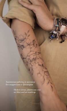 a woman's arm with flowers on it and the words in russian above her