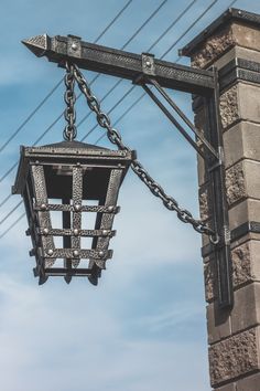 an old fashioned street light hanging from the side of a building