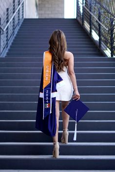 a woman walking up some steps with her graduation sash