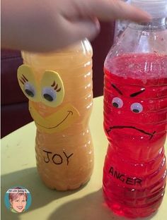 a child's hand reaching for a plastic water bottle with an angry face on it