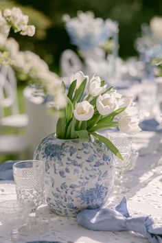 white flowers in a blue and white vase on a table