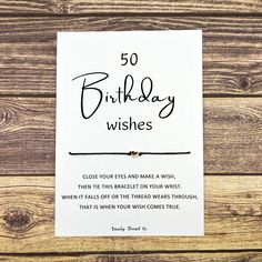 a card with the words, 50 birthday wishes on it and a string bracelet attached to it