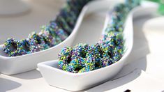 two white bowls filled with sprinkles sitting on top of a table next to each other