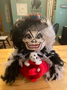 a creepy doll holding a stuffed animal on top of a wooden table in a room