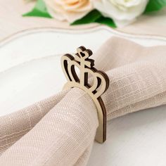 a napkin with a ring on it sitting on top of a table next to flowers