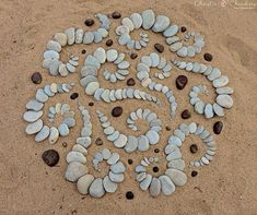 several rocks arranged in the shape of a spiral on top of sand with small pebbles