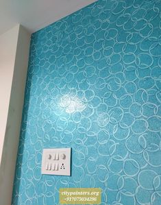 a blue wall with white circles on it and a light switch in the corner next to it