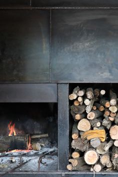 logs are stacked next to each other in front of a fire