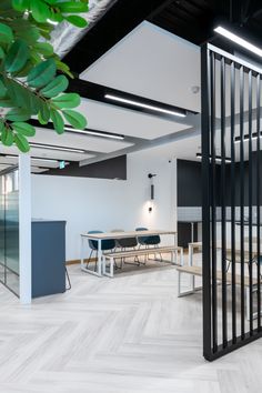 an empty office with tables and chairs in the center, surrounded by black partitions