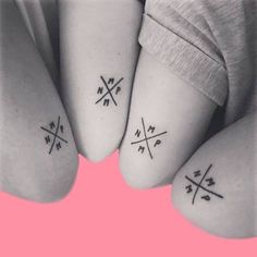 three small tattoos on the feet of two people with crossed crosses and arrows in them