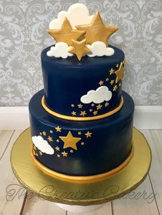 a blue cake with gold stars and clouds on top