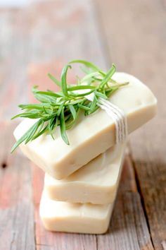 three soap bars stacked on top of each other with green sprigs attached to them