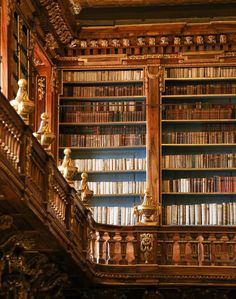 an old wooden bookcase with many books on it's shelves and railings