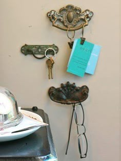 there is a hat, glasses and keys on the wall next to a plate with a fork