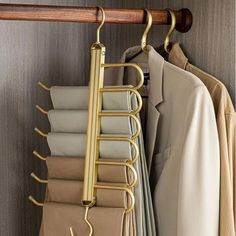 a coat rack with clothes hanging from it's sides and two coats on hangers