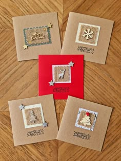 four christmas cards on top of a wooden table