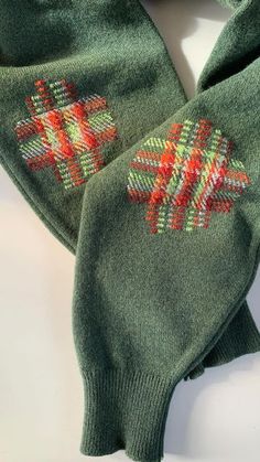 green mittens with red and yellow designs on them