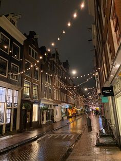 an empty city street at night with lights strung overhead